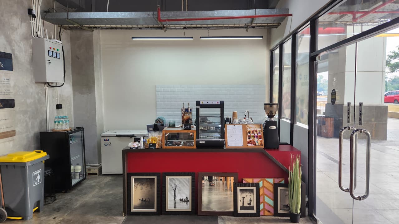 Bar kopi dengan penggiling espresso dan etalase kue