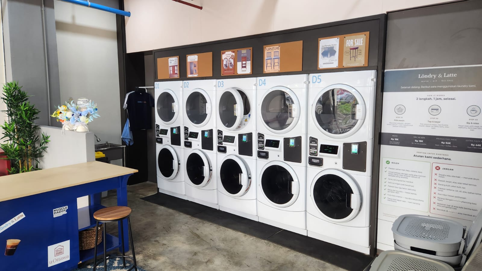 Interior Löndry & Latte: lima unit mesin cuci-pengering Maytag di samping meja biru